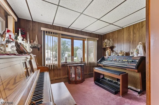 a living room with furniture a flat screen tv and a floor to ceiling window