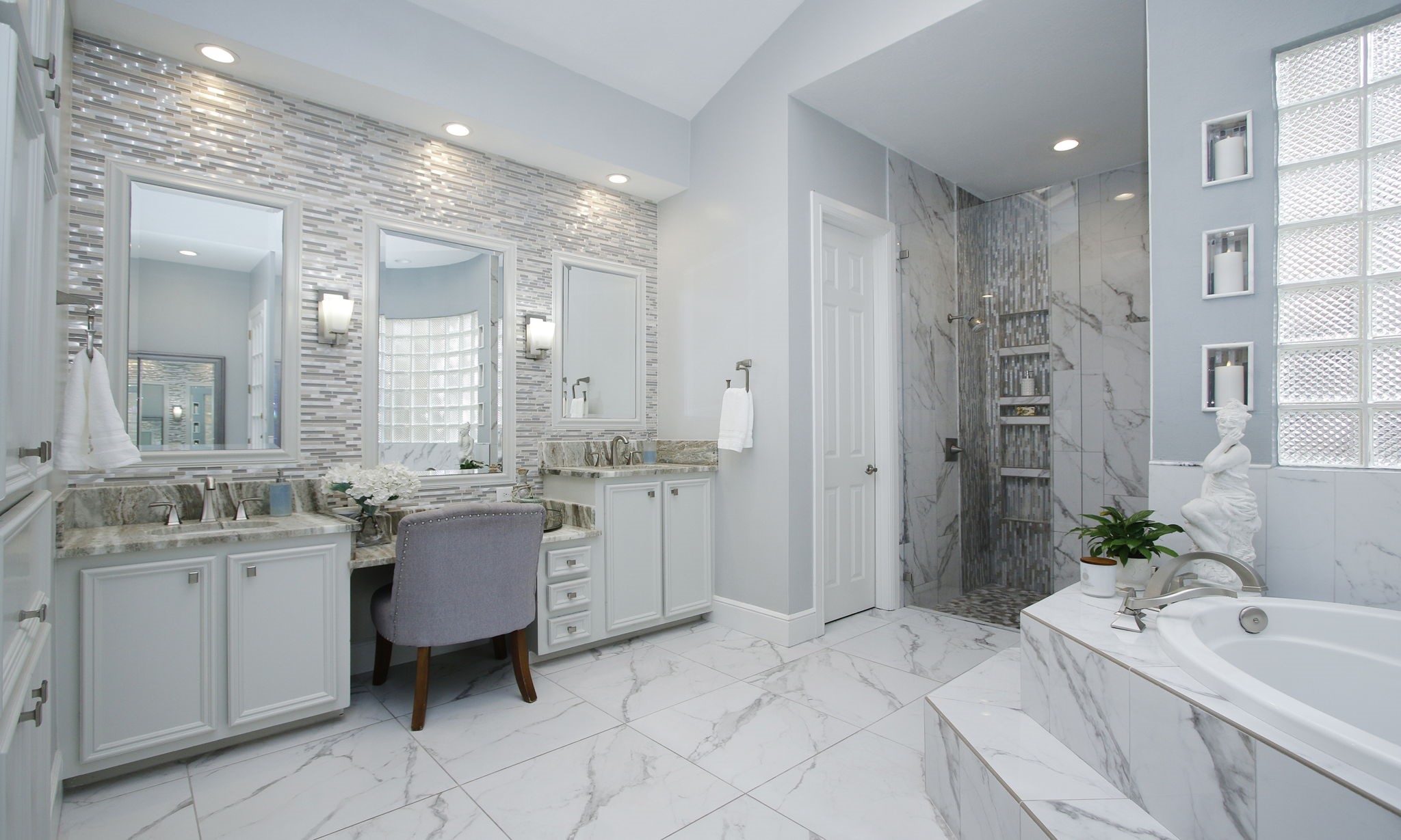 16610 Manningtree Lane Spring, TX 77379 - Photo 18 of 50 The wall behind the vanity glows from the backsplash tiles and sconce lighting.