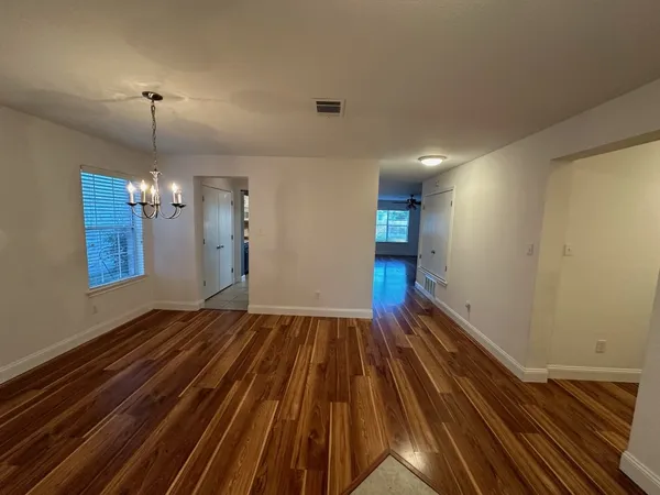 a view of an empty room with wooden floor