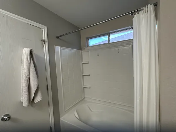 a bathroom with a glass shower door and a tub