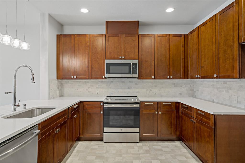 a kitchen with stainless steel appliances granite countertop wooden cabinets a sink and dishwasher