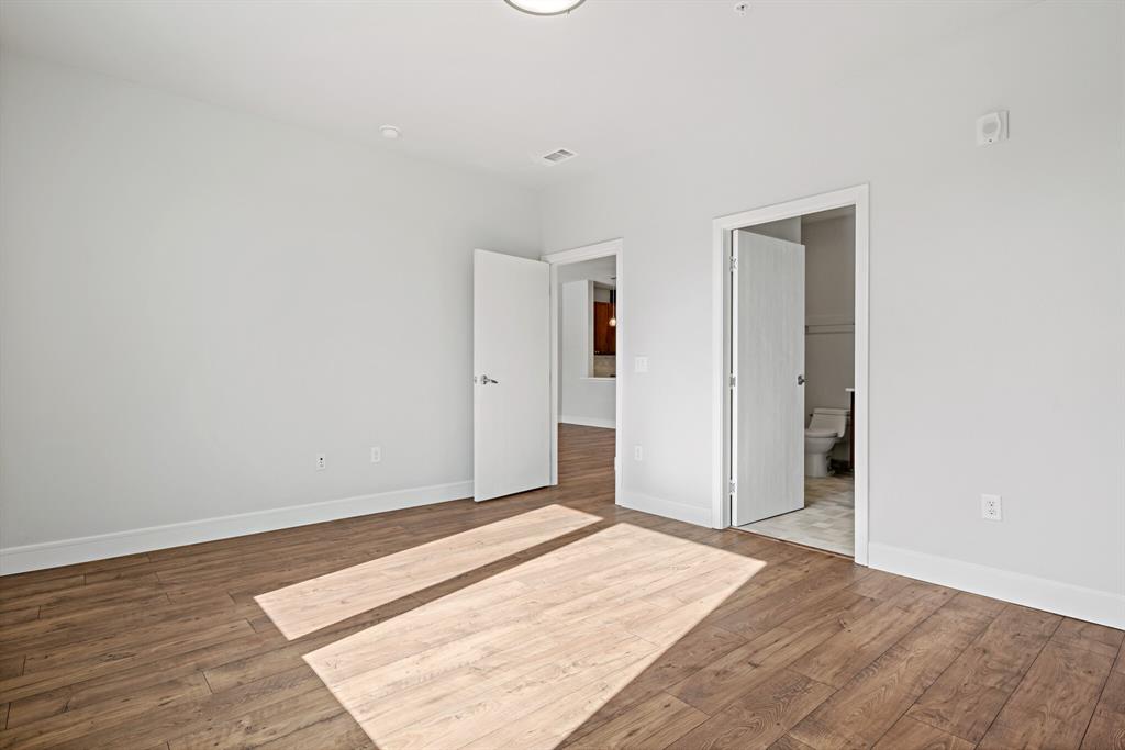 1220 West Trinity Mills Road, Unit 2011 Carrollton, TX 75006 - Photo 5 of 13 a view of a room with wooden floor and white walls