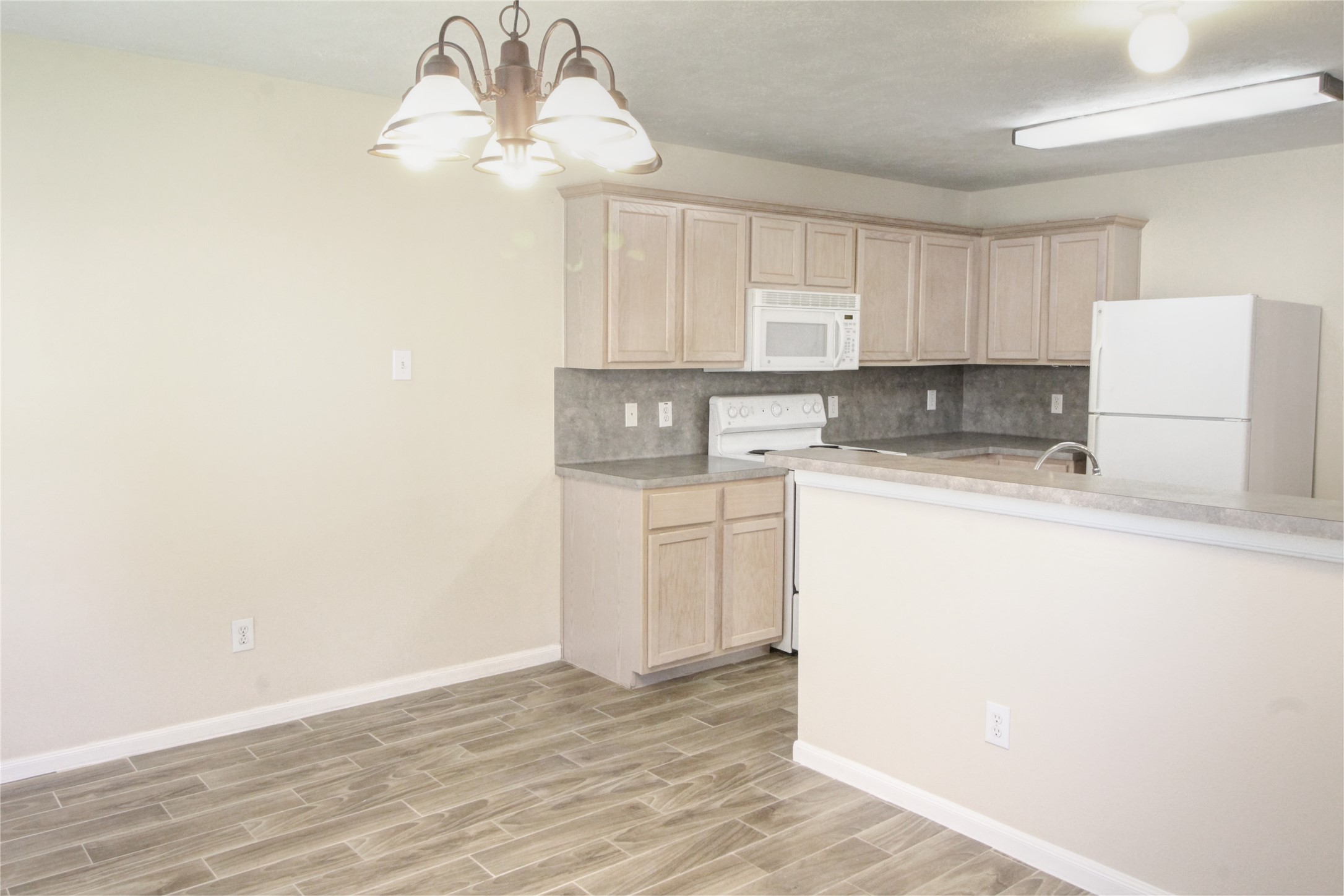 5530 Violet Path Lane Houston, TX 77085 - Photo 5 of 17 a kitchen with a refrigerator a stove a microwave and cabinets