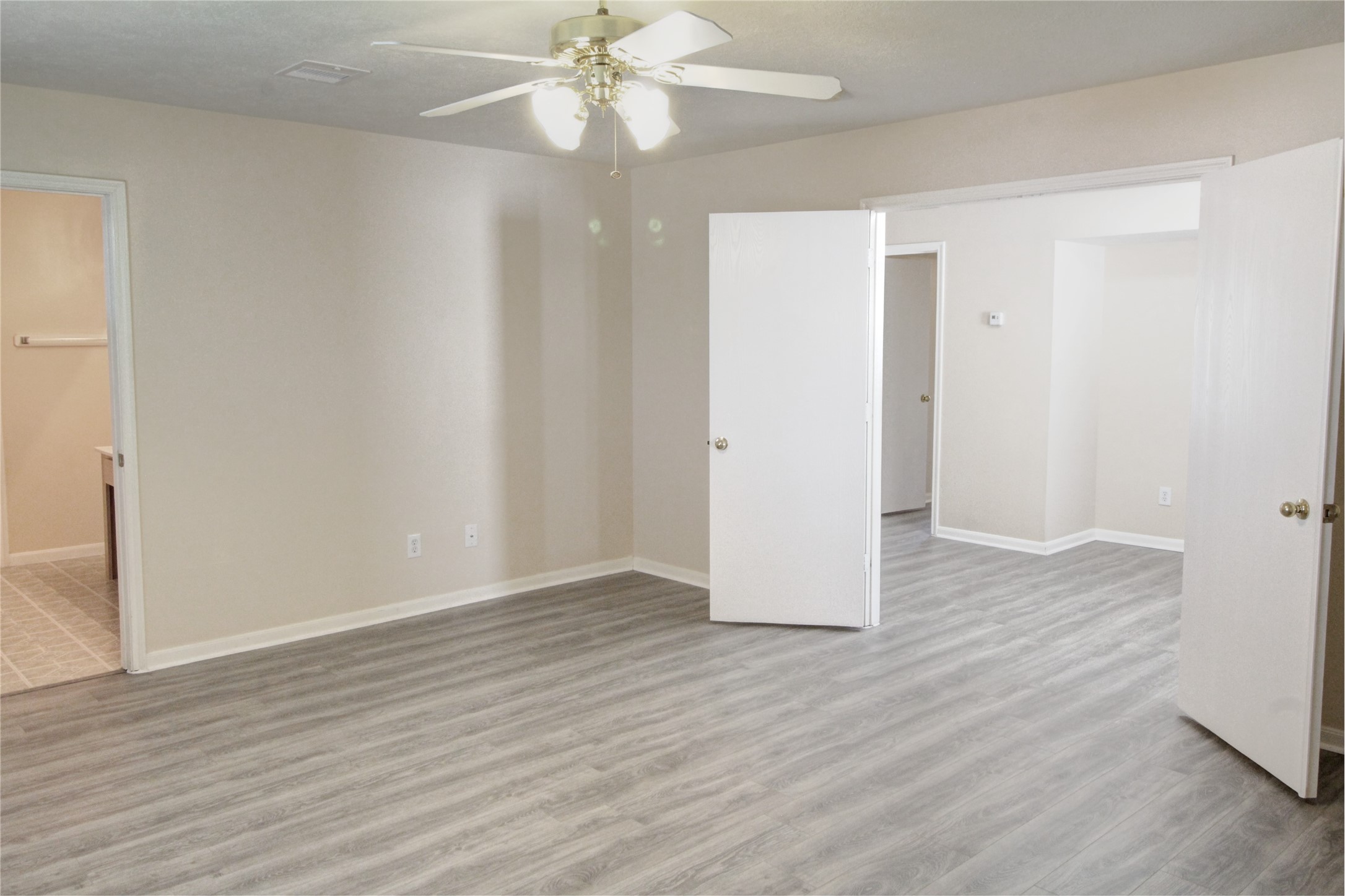 5530 Violet Path Lane Houston, TX 77085 - Photo 10 of 17 an empty room with wooden floor chandelier fan and closet area