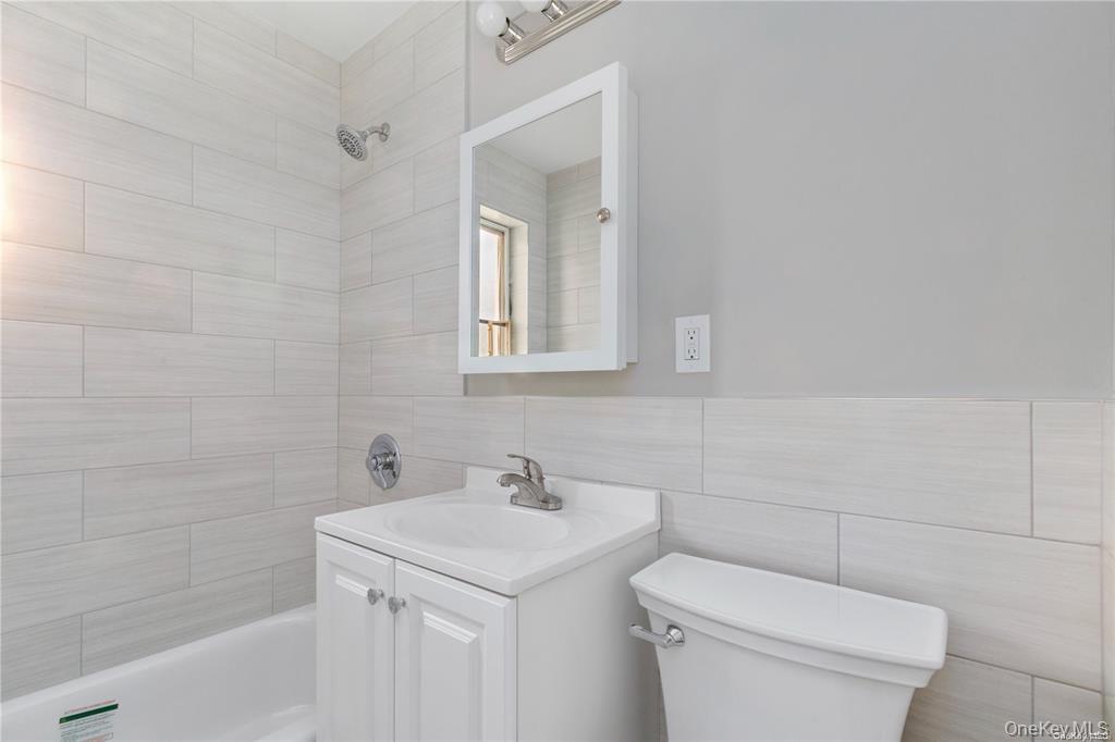 220-06 Stronghurst Avenue, Unit UPPR Queens, NY 11427 - Photo 11 of 12 a bathroom with a sink toilet and vanity