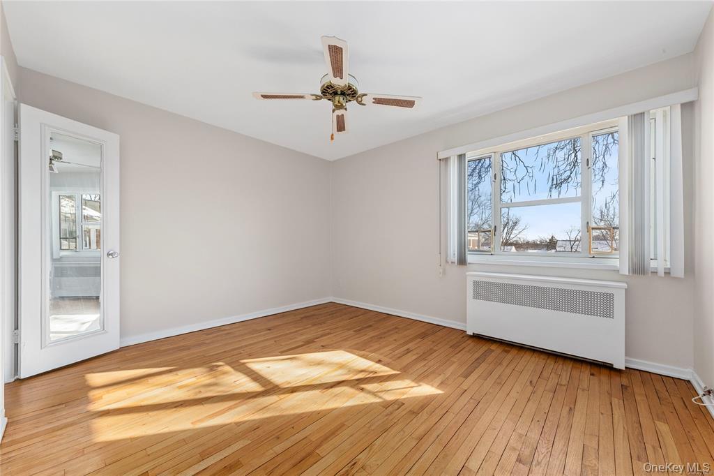 220-06 Stronghurst Avenue, Unit UPPR Queens, NY 11427 - Photo 4 of 12 a view of an empty room with a window and wooden floor