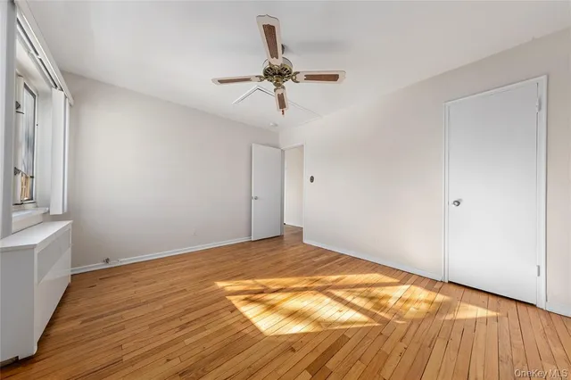 a view of a room with wooden floor and ceiling fan