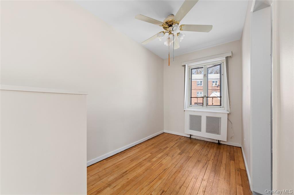 220-06 Stronghurst Avenue, Unit UPPR Queens, NY 11427 - Photo 7 of 12 an empty room with a hardwood and ceiling fan