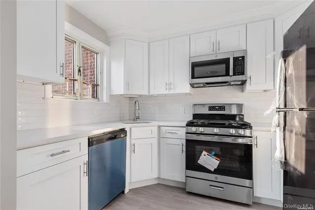 a kitchen with stainless steel appliances a stove microwave and sink