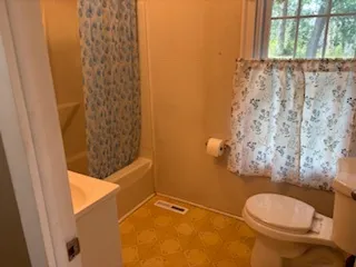 a bathroom with a toilet and shower curtain