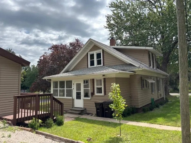 a house with a big yard and potted plants in front of the house