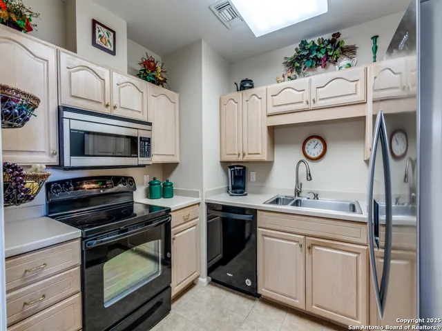 a kitchen with cabinets a window and stainless steel appliances