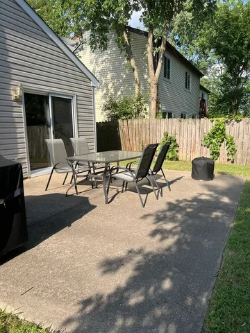 a view of a house with backyard and sitting area