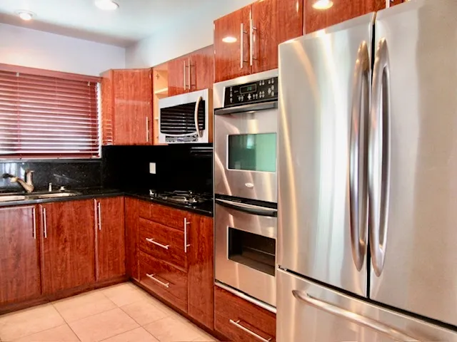 a kitchen with stainless steel appliances granite countertop a refrigerator and a stove top oven