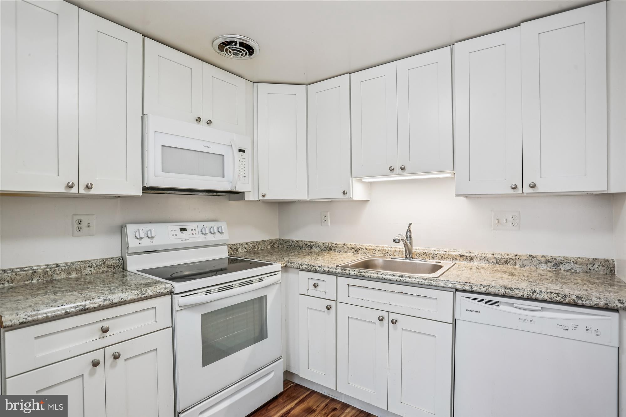 18801 Nathans Place Gaithersburg, MD 20886 - Photo 12 of 60 a kitchen with granite countertop white cabinets and white appliances