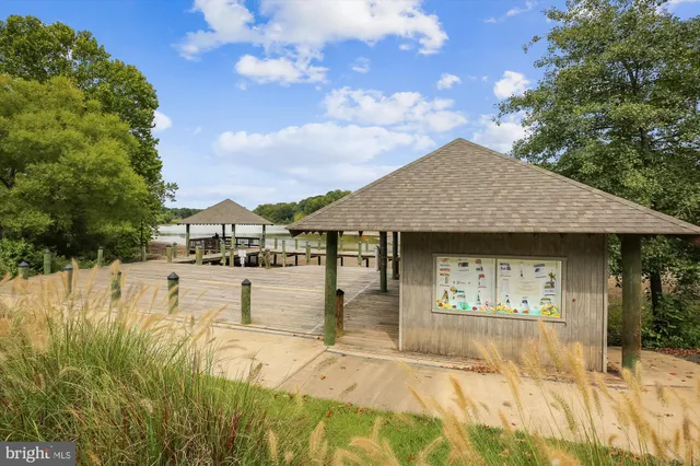a front view of a house with a large window and potted plants