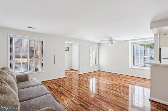 a view of a kitchen with wooden floor and a ceiling fan