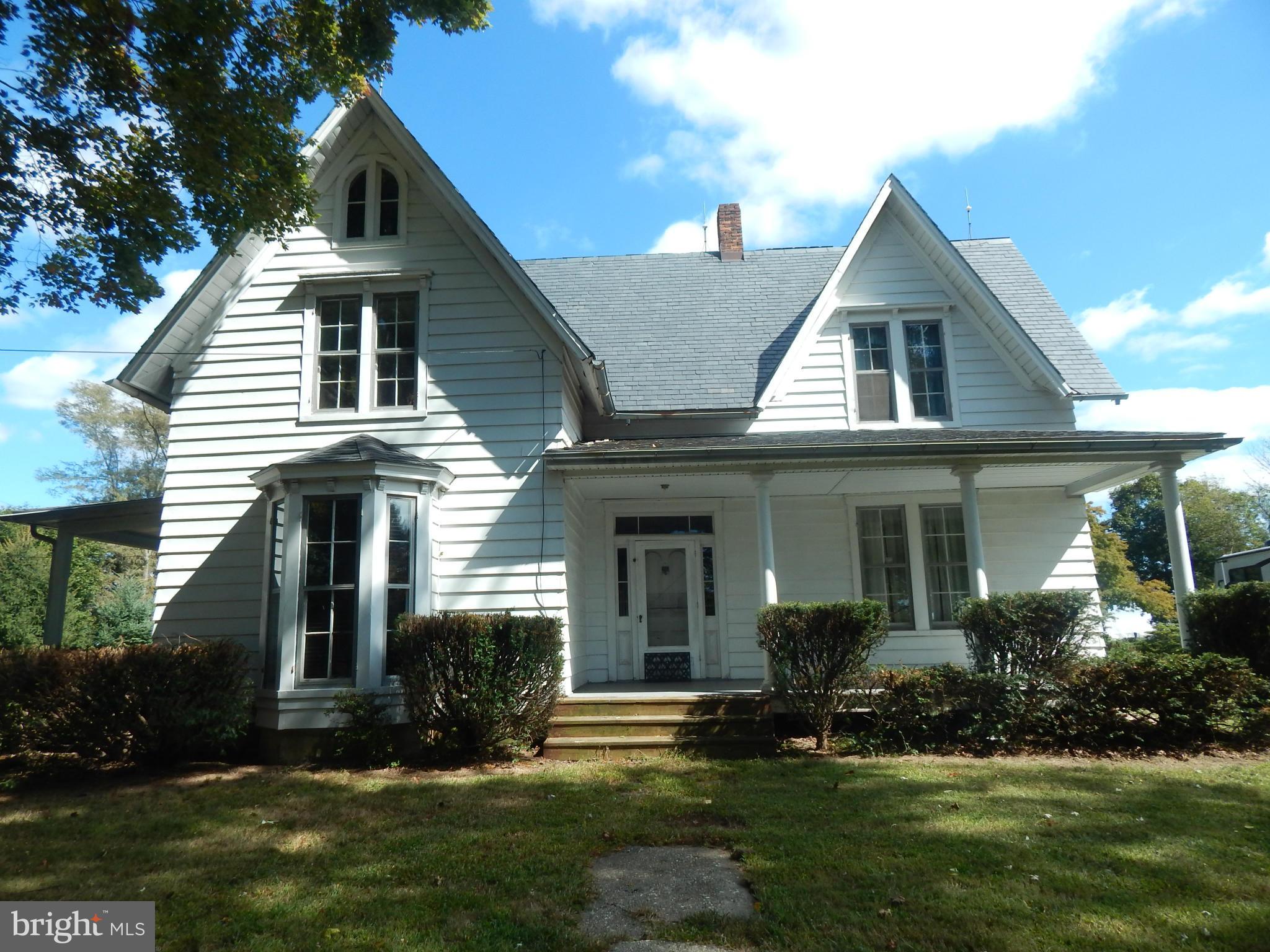 a front view of a house with a yard and trees