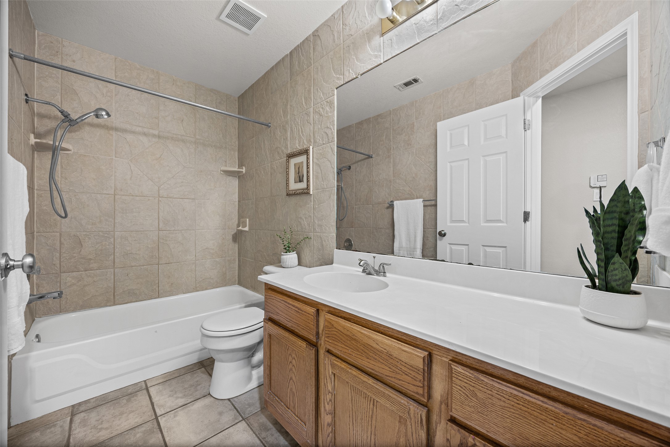 1524 Lochaline Loop Pflugerville, TX 78660 - Photo 18 of 22 Functional bathroom featuring a tub and shower combination with a wide vanity and substantial mirror.