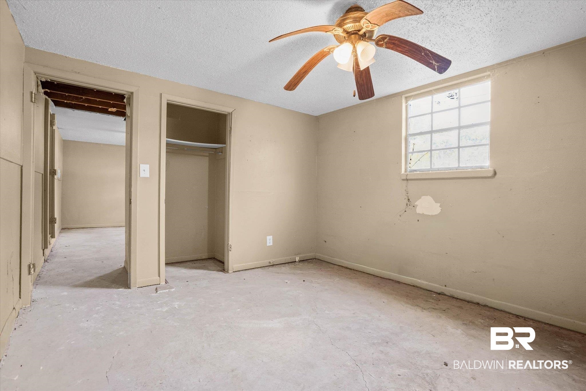 401 Frederick Avenue Fairhope, AL 36532 - Photo 16 of 36 Spacious interior room featuring a ceiling fan with light fixture, a window with gridded panes, and a built-in closet with shelving and hanging rod