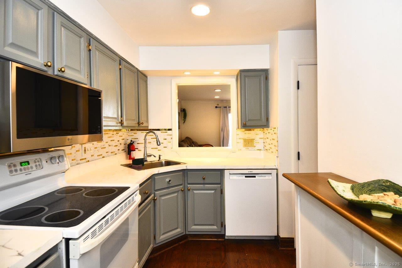 178 Flax Hill Road, Unit C203 Norwalk, CT 06854 - Photo 11 of 35 a kitchen with a sink stove top oven and cabinets