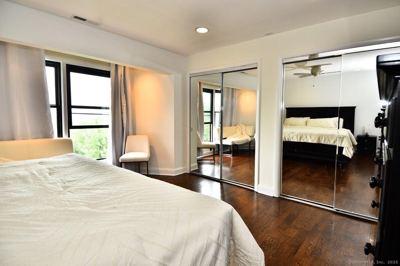 178 Flax Hill Road, Unit C203 Norwalk, CT 06854 - Photo 19 of 35 a bedroom with a bed and wooden floor
