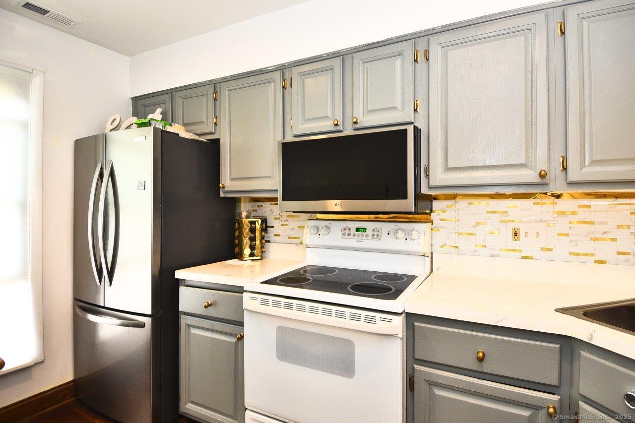 178 Flax Hill Road, Unit C203 Norwalk, CT 06854 - Photo 9 of 35 a kitchen with stainless steel appliances a refrigerator stove and microwave