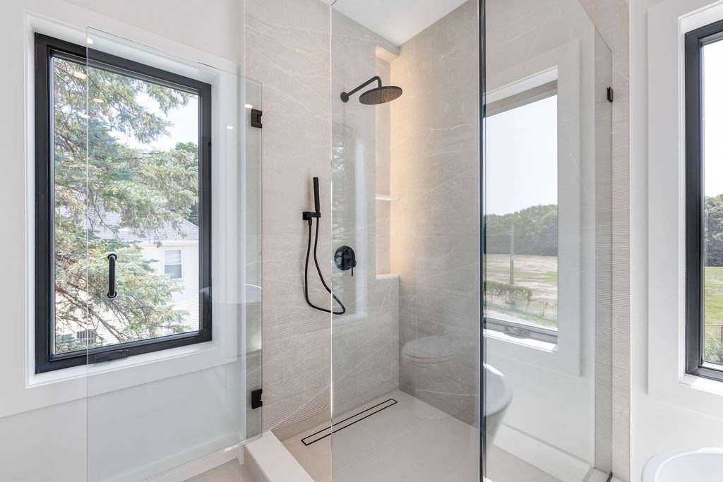 40 Otis, Unit L Needham, MA 02492 - Photo 11 of 19 a bathroom with a glass shower door and a window