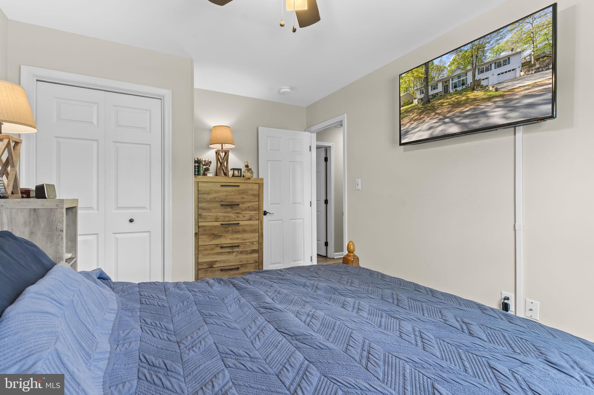205 Pawnee Lane Lusby, MD 20657 - Photo 20 of 37 a view of a bedroom with wooden floor closet and windows