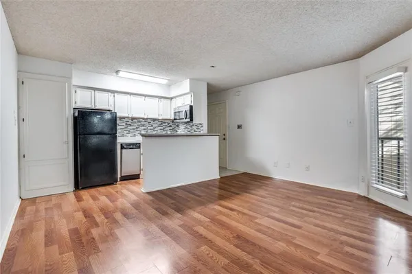 a view of a kitchen with a refrigerator wooden floor kitchen view and a window
