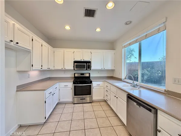 a kitchen with stainless steel appliances a sink stove and cabinets