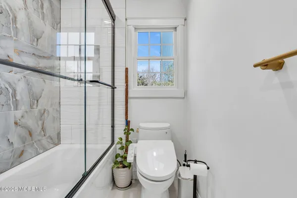 a white toilet sitting next to a bath tub