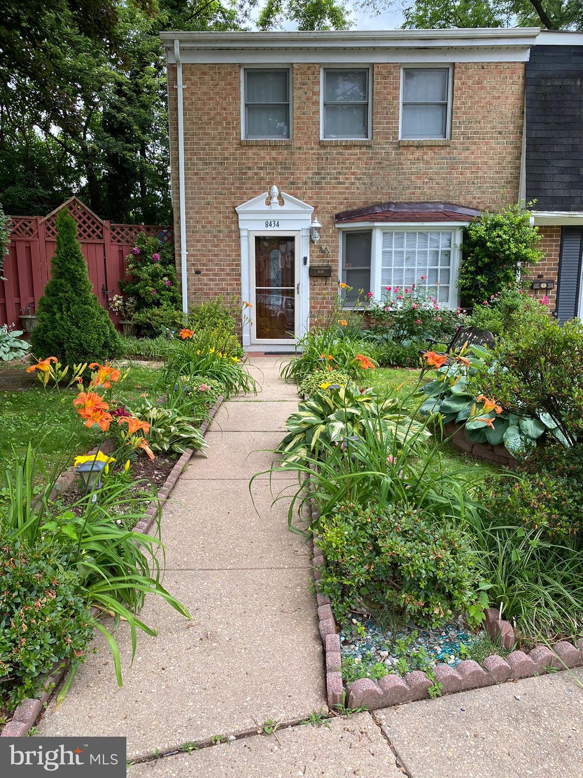 a view of a brick house with a yard and plants