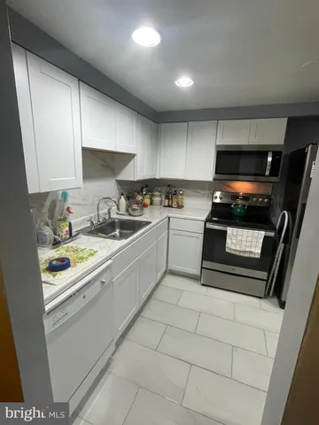 a kitchen with a stove white cabinets and a sink