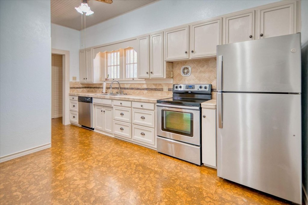 205 East Rainey Street Mason, TX 76856 - Photo 12 of 37 a kitchen with stainless steel appliances white cabinets and a refrigerator