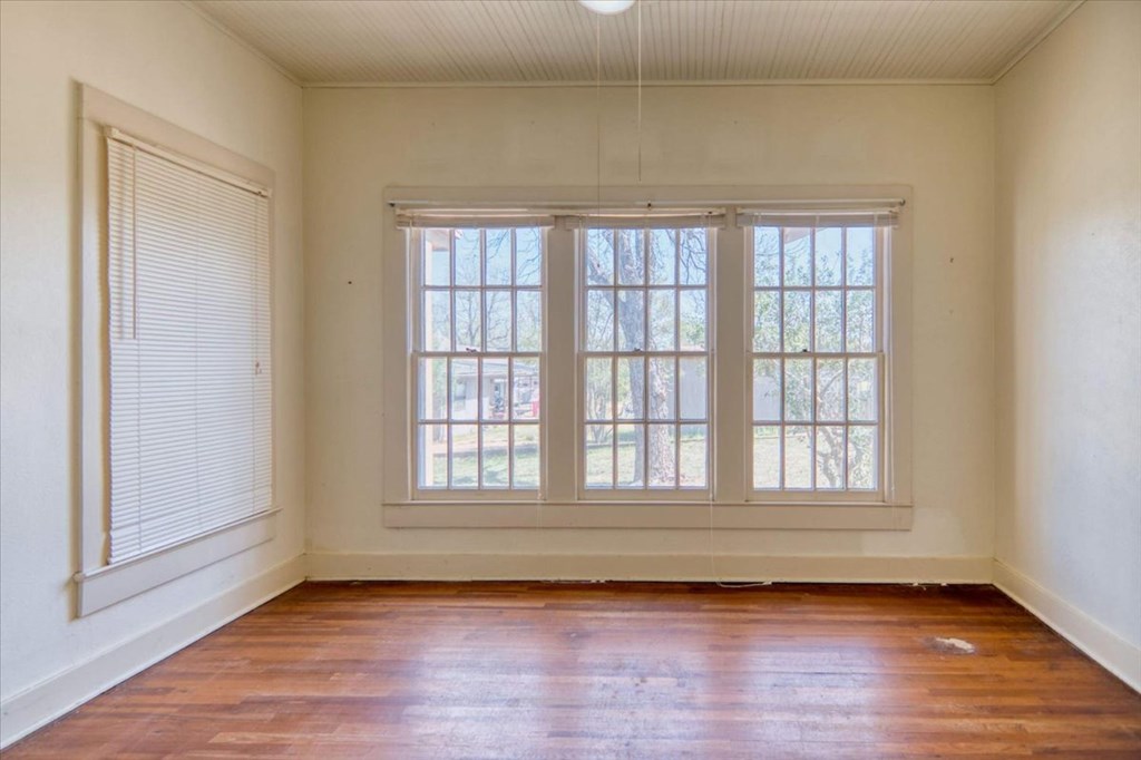 205 East Rainey Street Mason, TX 76856 - Photo 14 of 37 a view of an empty room with wooden floor and window