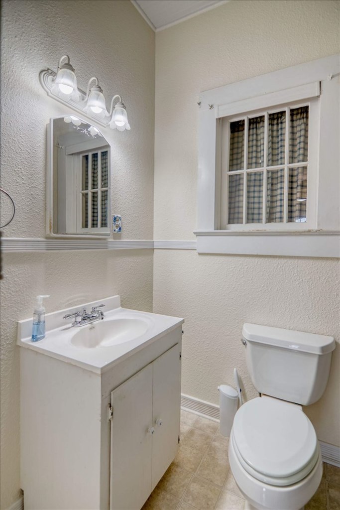 205 East Rainey Street Mason, TX 76856 - Photo 15 of 37 a bathroom with a toilet a sink and a mirror