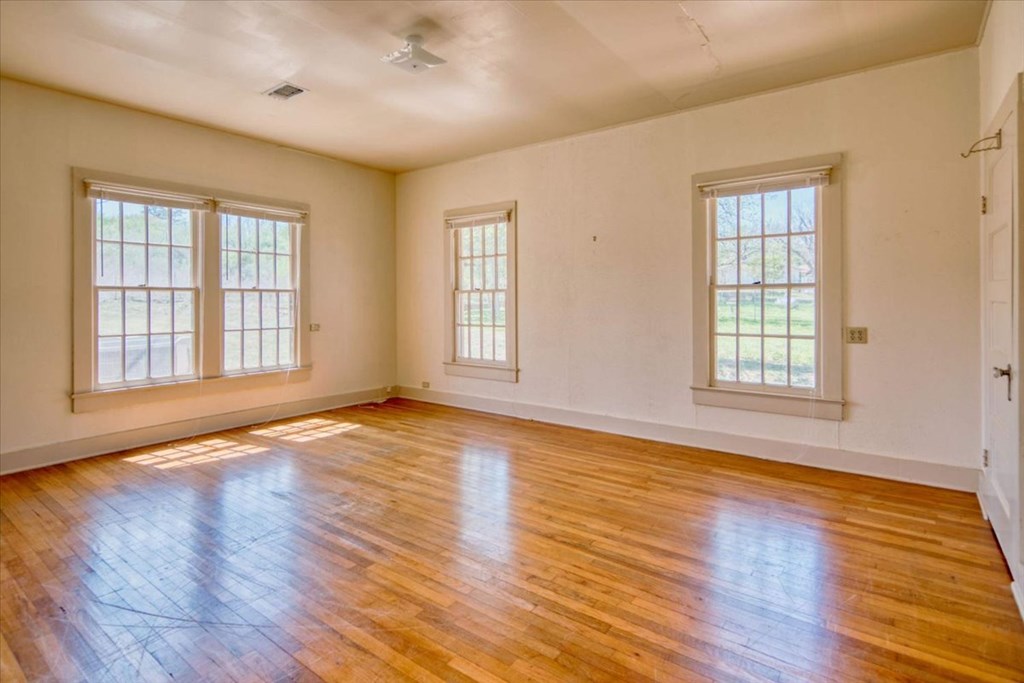 205 East Rainey Street Mason, TX 76856 - Photo 18 of 37 a view of an empty room with wooden floor and a window