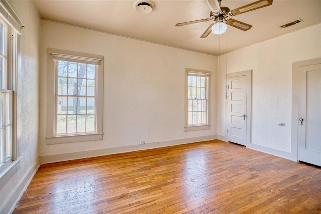 205 East Rainey Street Mason, TX 76856 - Photo 21 of 37 a view of an empty room with wooden floor and window