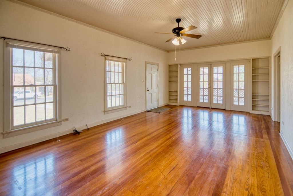 205 East Rainey Street Mason, TX 76856 - Photo 8 of 37 a view of an empty room with wooden floor and a window