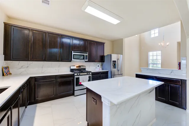 a kitchen with a sink a stove a refrigerator cabinets and a window