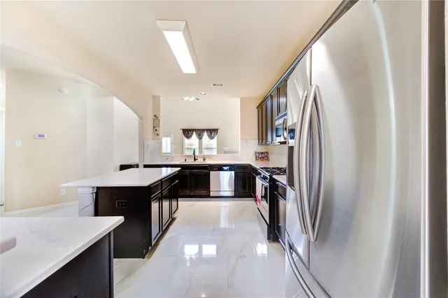 a kitchen with stainless steel appliances granite countertop a refrigerator and a sink