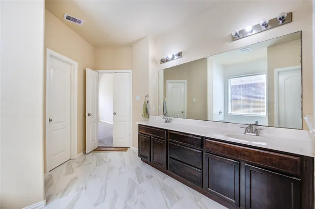 a bathroom with a double vanity sink and mirror