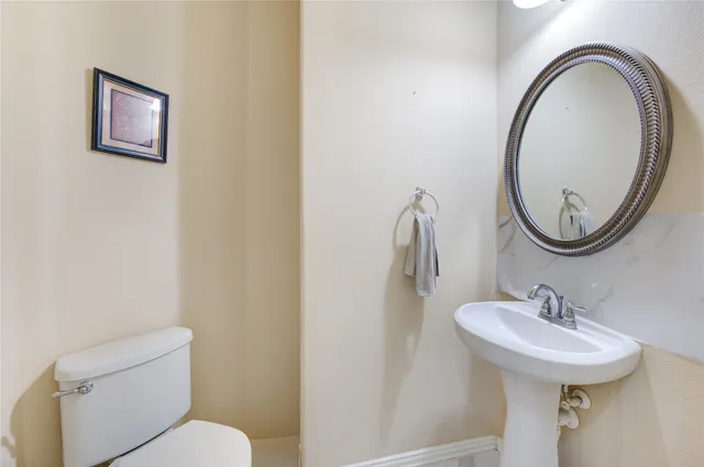 a bathroom with a toilet a sink and a mirror