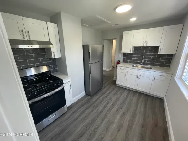 a kitchen with stainless steel appliances a stove a sink and a refrigerator