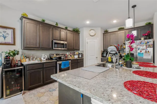 a kitchen with granite countertop lots of counter top space appliances and cabinets