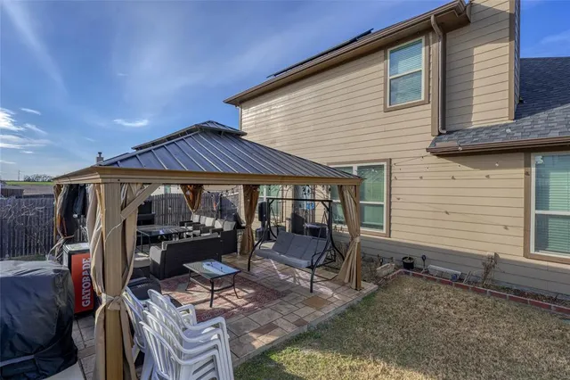 a view of a patio with table and chairs under an umbrella