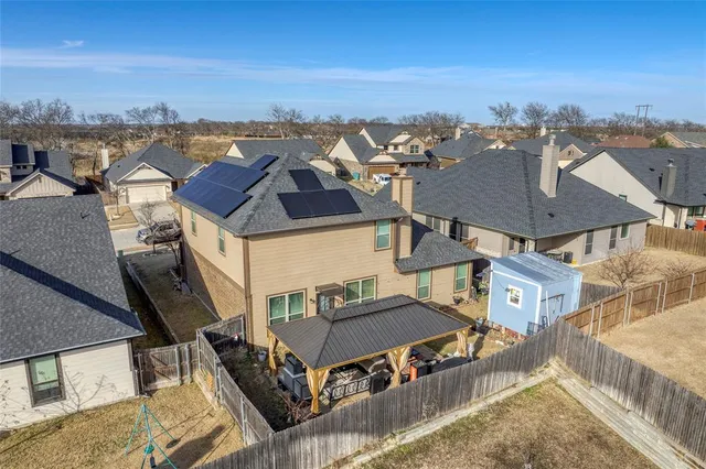 an aerial view of residential houses with outdoor space and ocean view