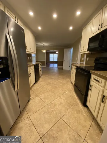 a kitchen with stainless steel appliances granite countertop a refrigerator a stove a sink and a microwave