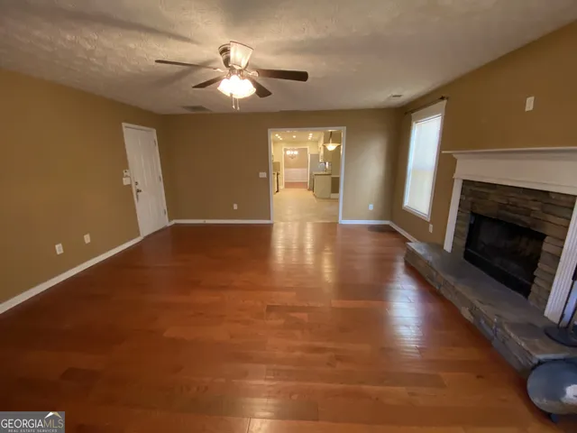 a view of an empty room with chandelier and fireplace